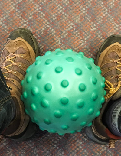 Feet with exercise ball in seated-exercise class