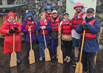 Group of men and women standing with their dragon boating paddles