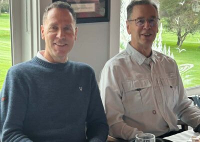 Two smiling men sitting at the Christmas lunch table