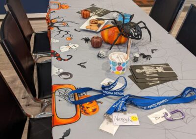 A table with Halloween decorations and tablecloth, cookies.