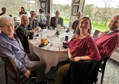 Happy group of people sitting around a table at the Victoria Golf Clug.
