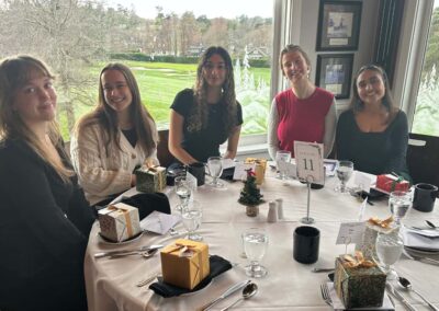 A group of young women who volunteer with the VSRA, sitting at a dining table and smiling.