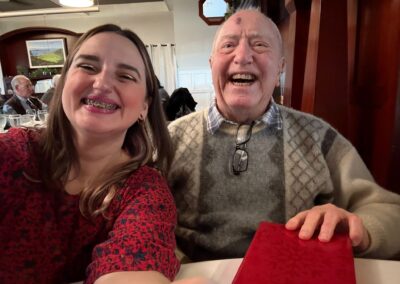 A young woman and elderly man with big smiles.