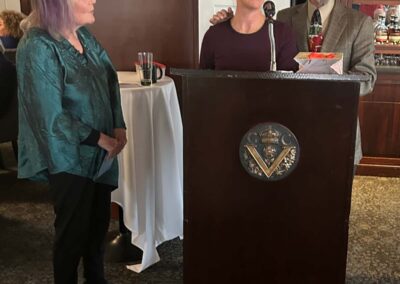 Two women and one man smiling at the podium