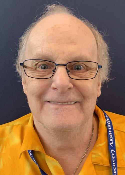 A smiling, balding older man with