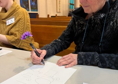 older woman with a flower pen drawing objects