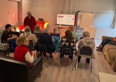 man teaching a group of older people with two young adults