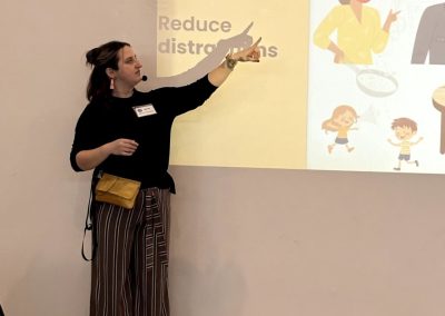 Woman standing and pointing to a screen that says "Reduce distractions."