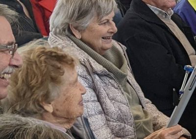 A smiling group of VSRA members sing and play instruments in the music therapy class.