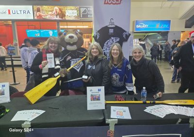 Smiling women with paddles at the hockey game