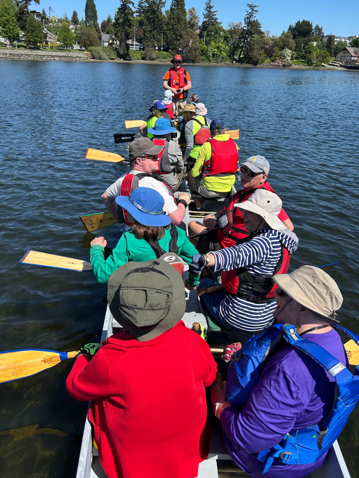 People sitting in the long, thin dragon boat, talking