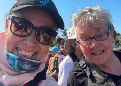 Two smiling women sitting in a dragon boat.