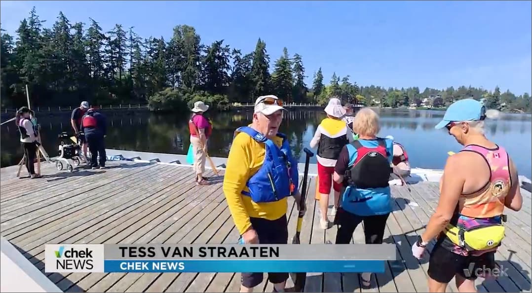 A group of people wearing workout clothes and life jackets on the kayaking dock at the Gorge Waterway